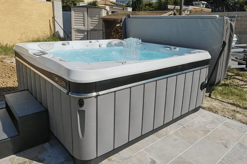 Grand spa Caldera en eau sur une terrasse carrelée près de la maison, à Villeveyrac