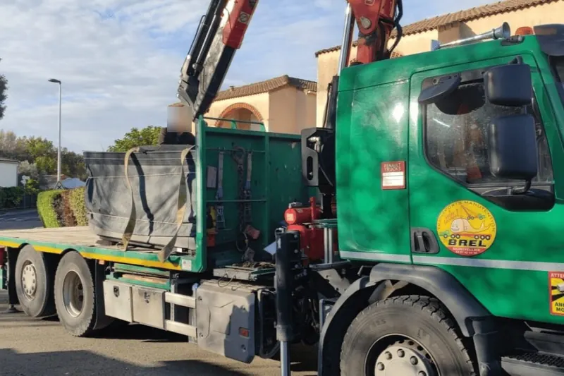 Camion-grue des Transports BREL chargé du spa bâché, garé dans une rue de Prades-le-Lez