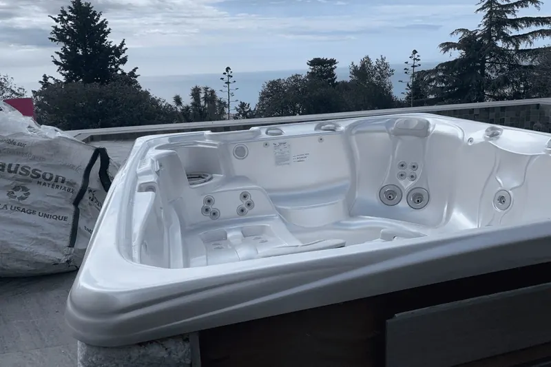 Cuve blanche du spa Caldera vue de près, la Méditerranée en arrière-plan