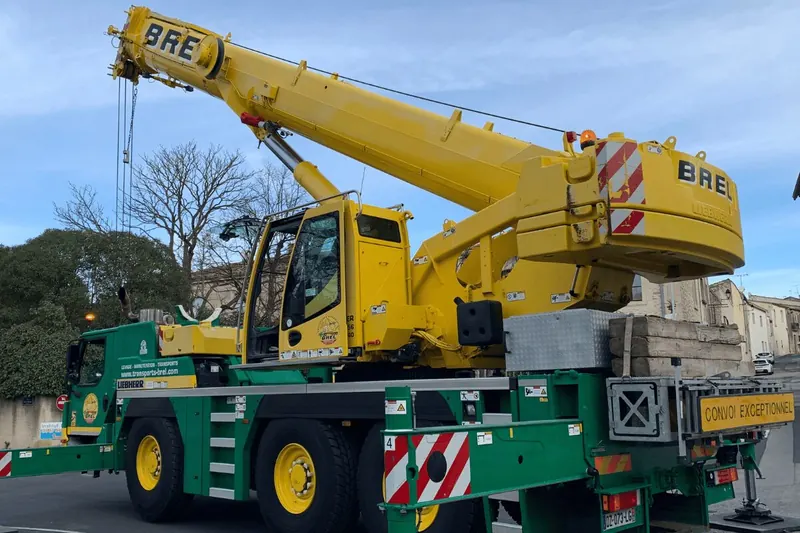 Grue jaune et verte des Transports Brel stationnée dans une rue de Saint-Jean-de-Védas