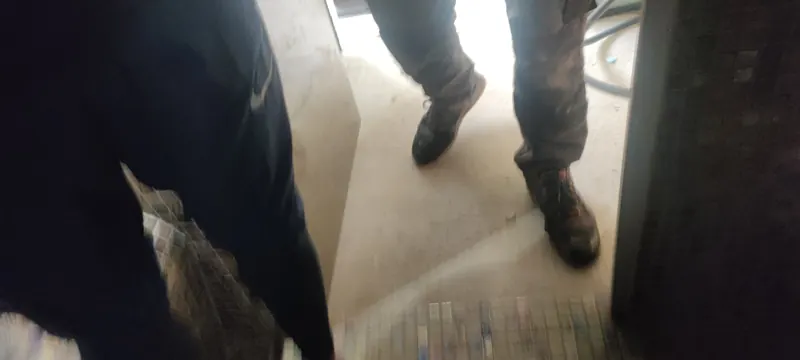 Jambes de techniciens au sol du hammam pendant les travaux