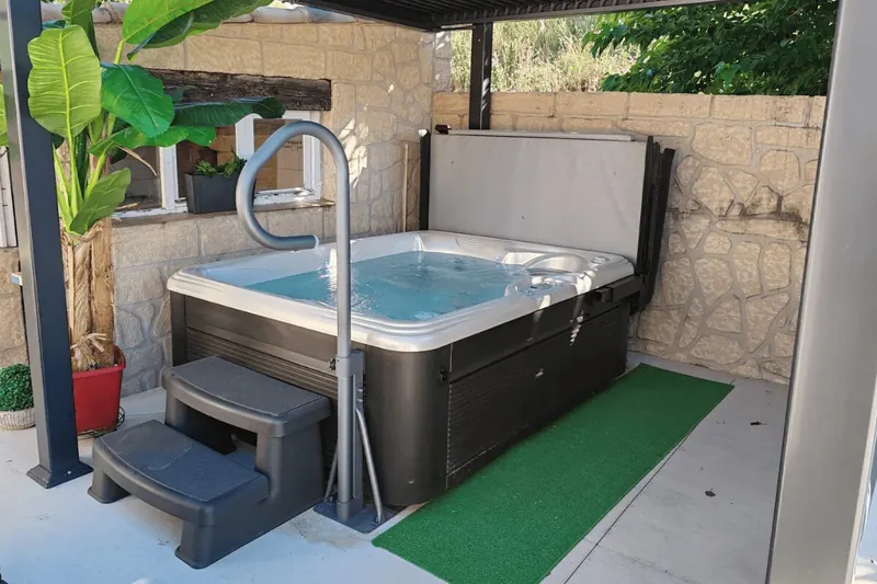 Spa Caldera Celio trois places en eau sous une pergola à Lavérune, marchepied et barre d'appui