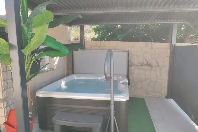 Spa Caldera Celio vu de face, barre d'appui en inox devant la cuve