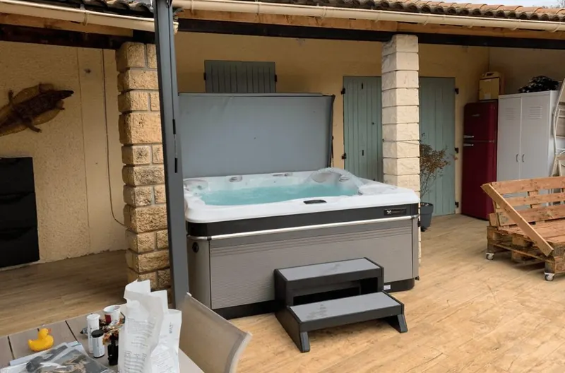 Spa Caldera Tahitian sous l'auvent avec son marchepied, cartons de livraison encore au sol