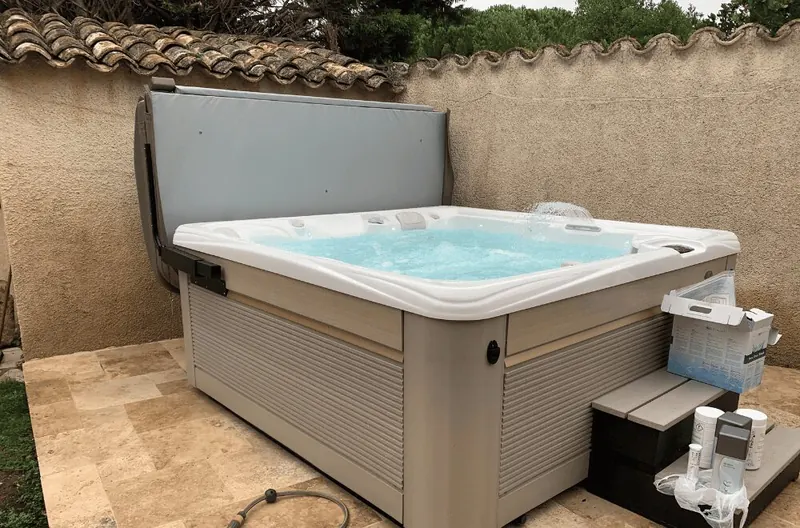 Spa Caldera Seychelles sur une terrasse dallée à Caux, marchepied et produits d'entretien au pied
