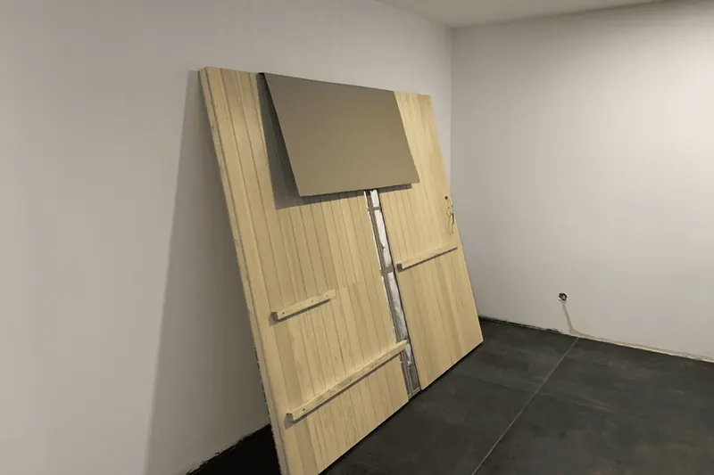 Panneaux en bois du sauna appuyés contre le mur de la pièce avant le montage, à Thézan-lès-Béziers