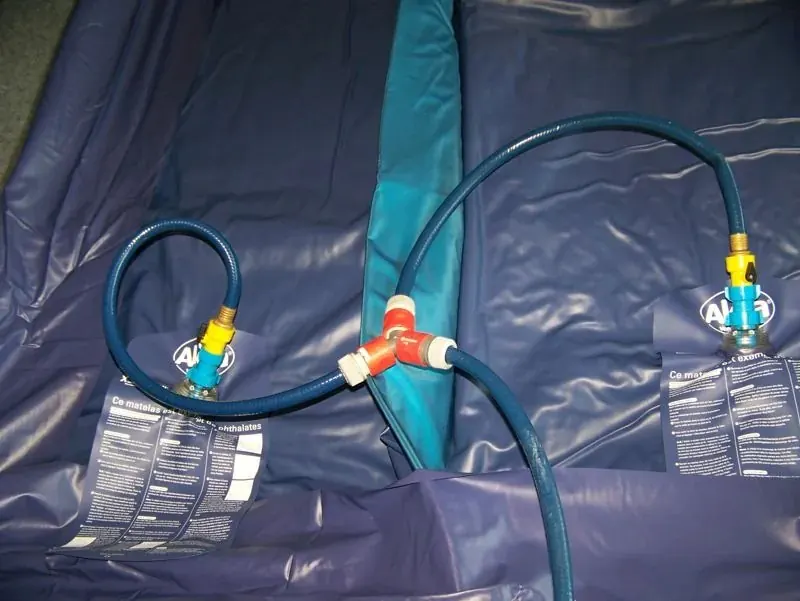 Deux matelas de lit à eau remplis, tuyaux raccordés à leurs valves par un raccord en Y