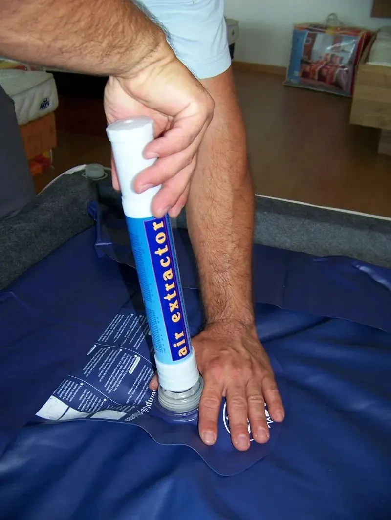 Extracteur d'air enfoncé sur la valve d'un matelas de lit à eau