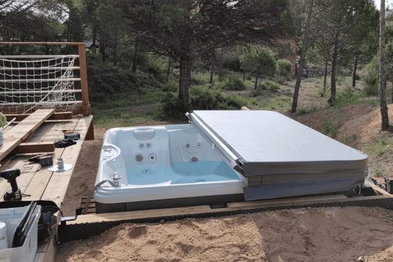 Spa Caldera Marino en cours de remplissage dans un jardin boisé de Mourèze
