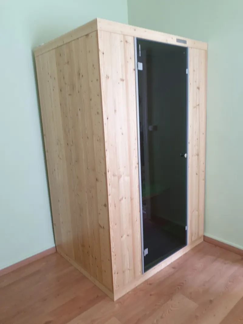 Cabine de sauna en bois clair avec sa porte vitrée