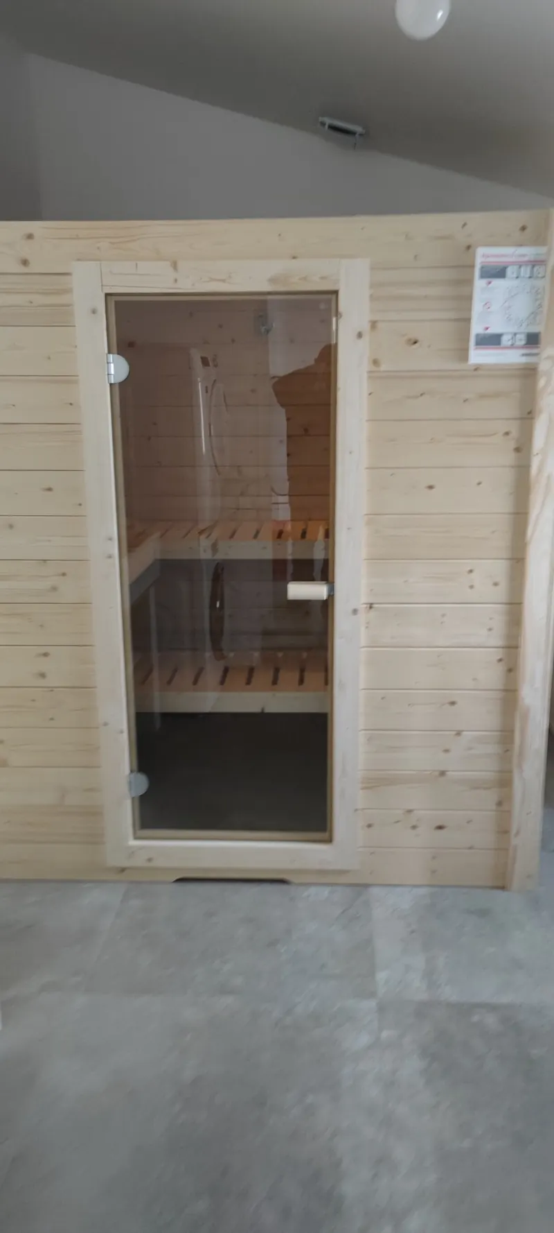 Intérieur éclairé, bancs en bois sur deux niveaux et fenêtre haute