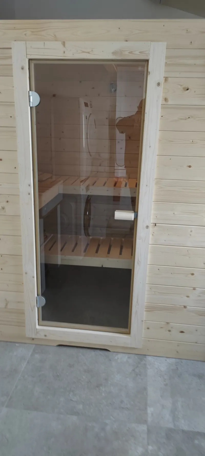 Porte blanche et bancs en bois vus de près, avec la fenêtre de ventilation