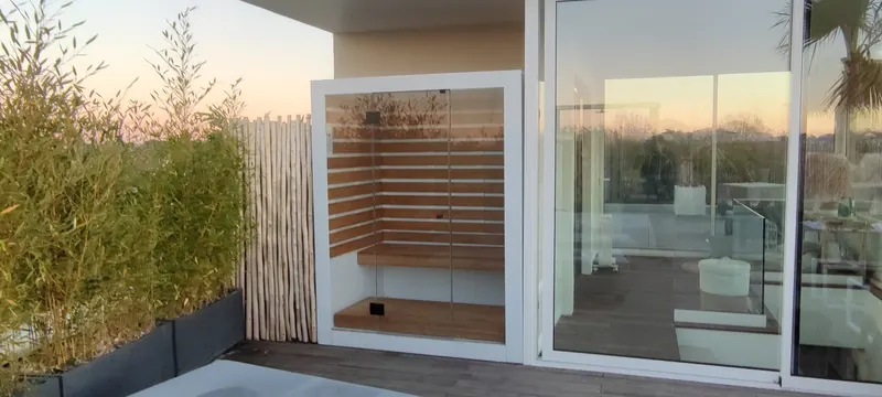 Sauna vu de face, avec le paysage verdoyant en arrière-plan