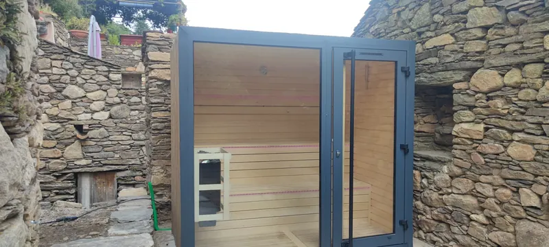 Portes du sauna ouvertes, entre les murs de pierre du passage