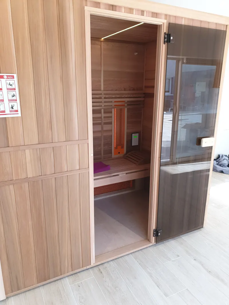 Sauna en bois ouvert : banc, émetteur infrarouge et bandeau lumineux au plafond, à Vic-la-Gardiole