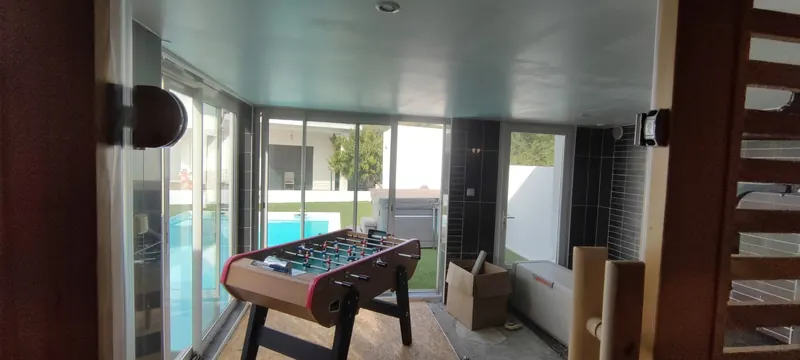 Sauna intégré à l'espace de bien-être, baies vitrées ouvertes sur la piscine extérieure