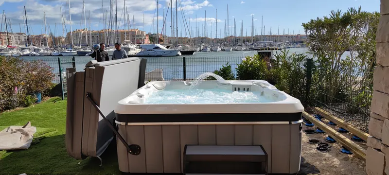 Spa gris rempli d'eau, avec vue sur le port et la végétation