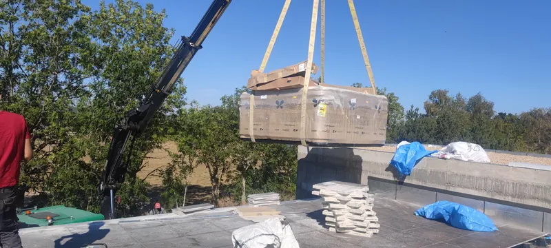 Spa levé à la grue, stabilisé par des haubans, au-dessus d'une forêt de montagne