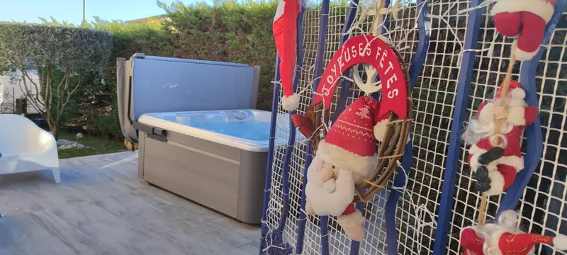 Spa derrière un filet de décoration de Noël avec des Pères Noël en peluche