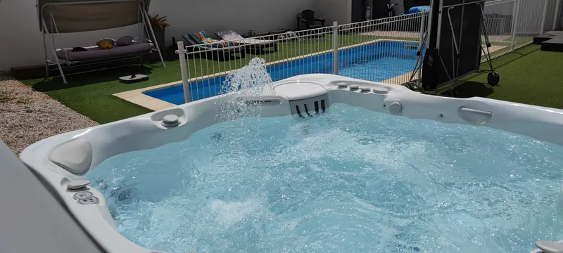 Spa en eau vu d'un autre angle, piscine rectangulaire au fond du jardin