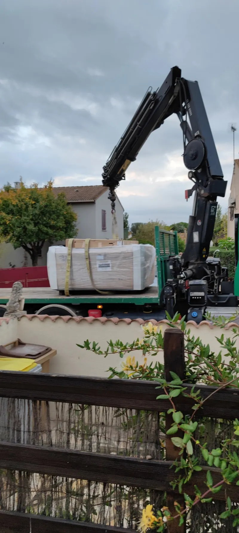Spa emballé, suspendu à la grue au-dessus du jardin