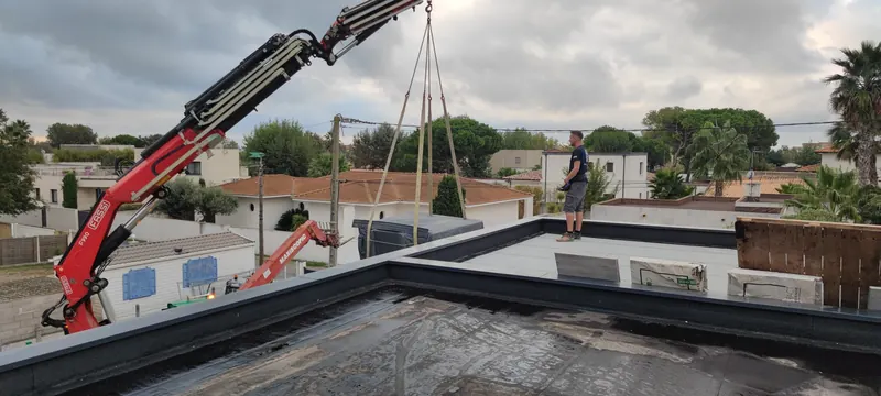 Levage du spa par la grue rouge, avec les maisons du quartier résidentiel autour