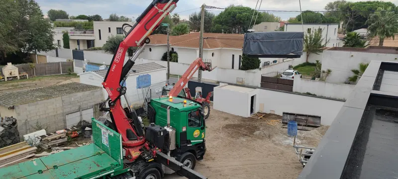 Spa en caisson suspendu à la grue rouge, vu en contre-plongée