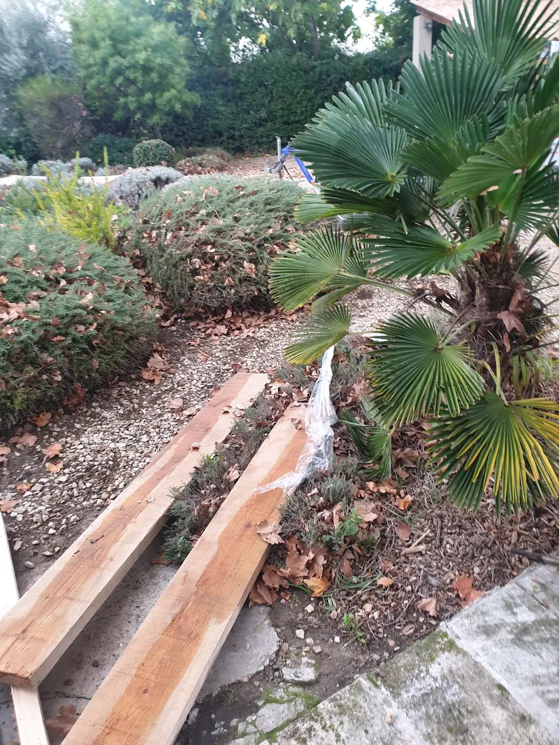 Madriers couchés en travers d'un massif de jardin pour ménager un passage