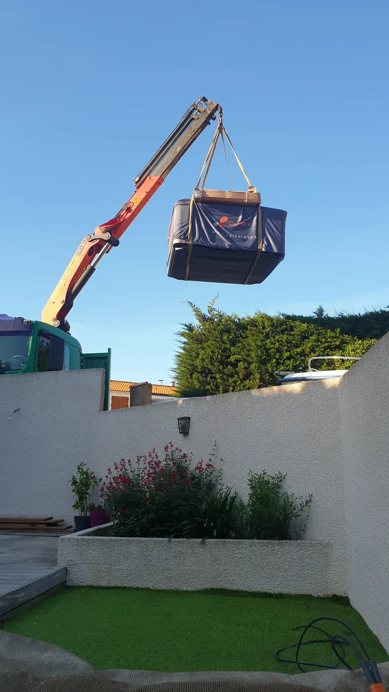 Spa emballé suspendu à la grue