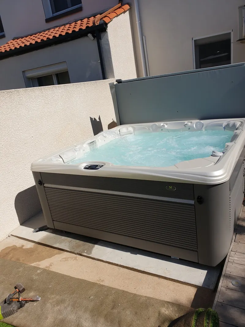 Spa blanc et gris rempli sur la terrasse carrelée