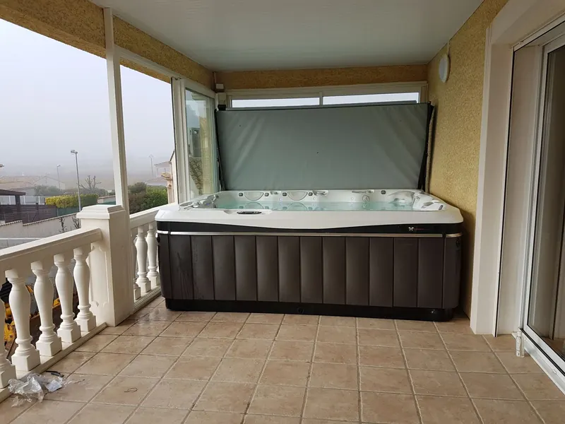 Spa Caldera Cantabria installé sur une terrasse couverte à l'étage, couverture relevée, à Lespignan