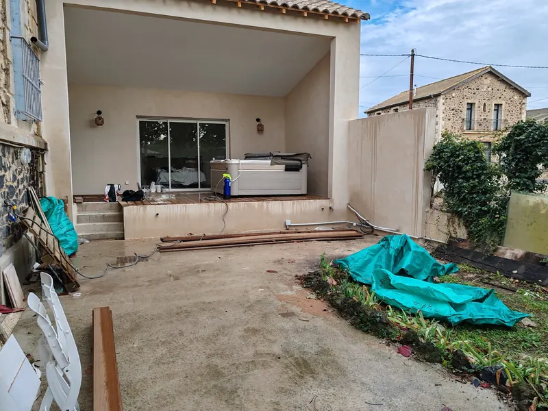 Spa posé dans l'angle de la terrasse en bois surélevée, couverture fermée
