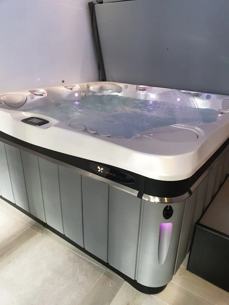 Spa Caldera en marche dans une pièce intérieure, éclairage et jet d'eau décoratif allumés
