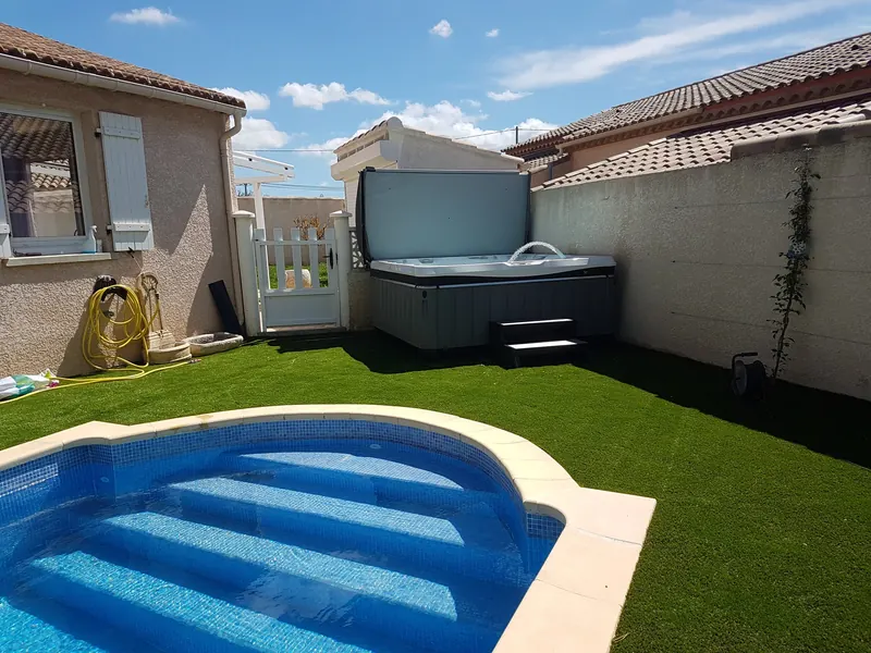 Spa en eau dans l'angle du jardin, vu depuis l'escalier de la piscine à Maureilhan