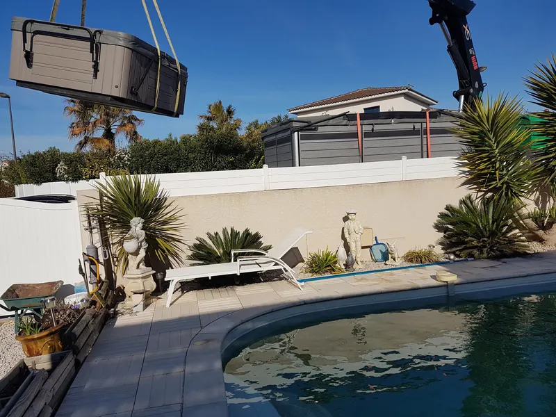 Spa Caldera Kauai sanglé à la grue au-dessus d'un jardin avec piscine à Balaruc-le-Vieux