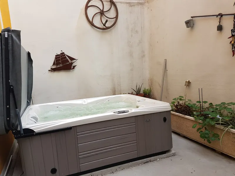 Spa Caldera Kauai en marche, eau bouillonnante, à côté d'une jardinière dans une cour à Bessan