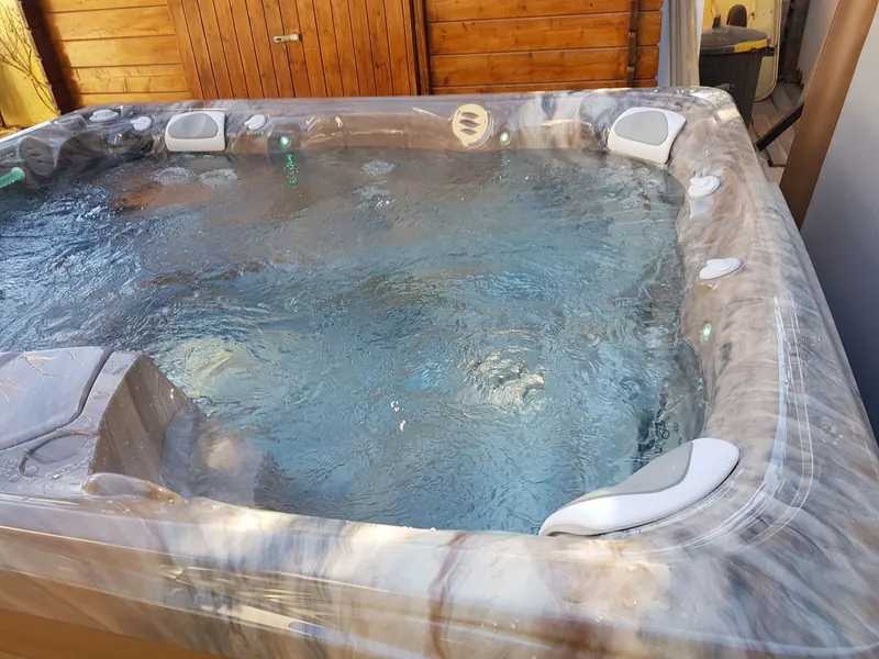 Bassin d'un spa Caldera en eau, appuie-têtes blancs et jets en marche, à Gigean