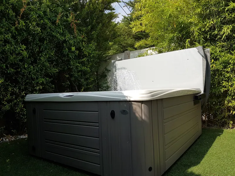 Spa ouvert, couverture relevée sur son lève-couverture, fontaine en marche à Poussan