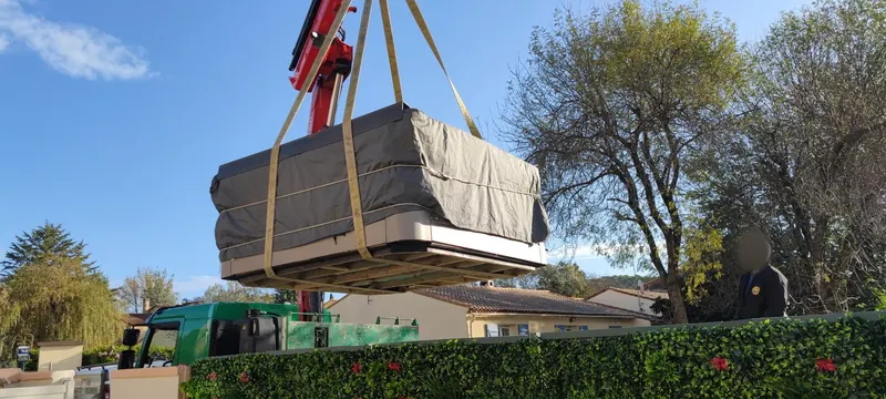 Spa enveloppé suspendu à la grue rouge au-dessus du jardin