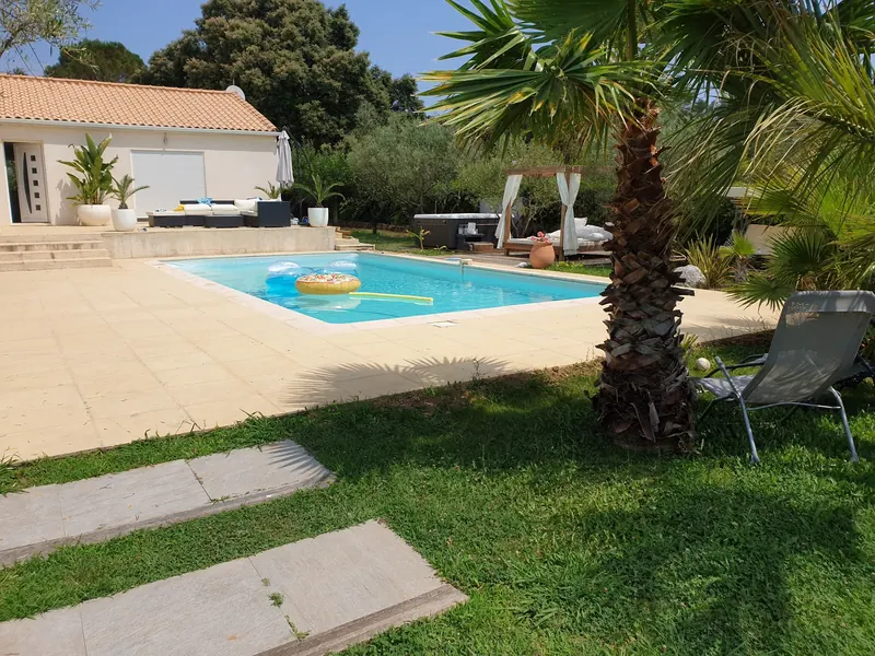 Jardin avec piscine, le spa visible au fond près d'un lit à baldaquin, à Saint-Jean-de-Cuculles