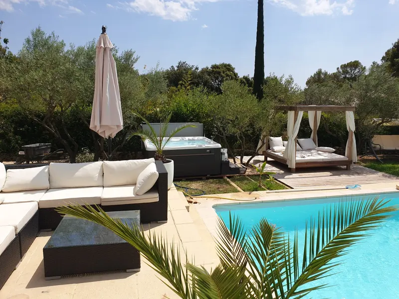Le spa vu depuis le salon de jardin, au-delà de la piscine et d'un palmier