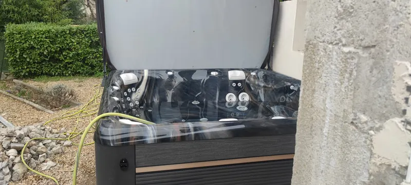 Intérieur du spa à coque marbrée sombre, jets et appuie-têtes, tuyau jaune sur le bord