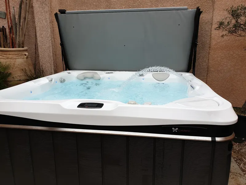 Bassin du spa Caldera Spas en marche, avec jet d'eau en arc et appuie-tête, à Sète