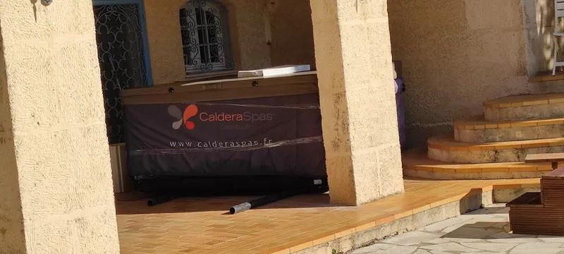 Housse du spa imprimée du logo Caldera Spas, tubes noirs posés au sol