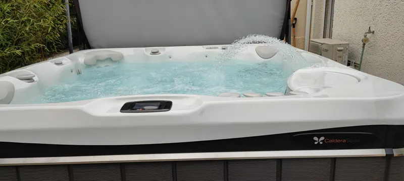 Logo Caldera Spas sur le spa blanc, eau turquoise en circulation