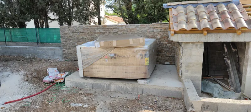 Spa emballé de carton à la livraison, murs du chantier en construction
