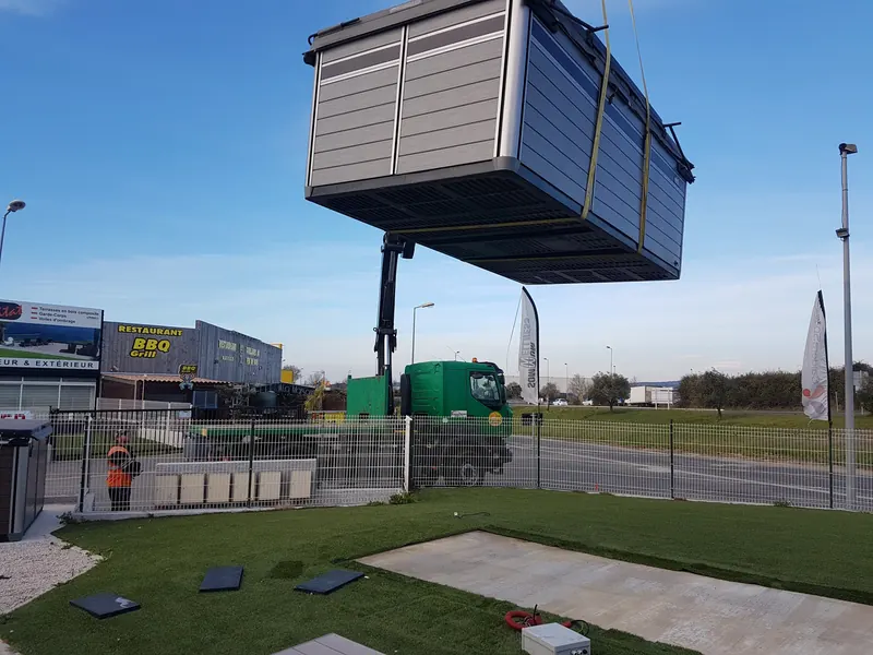 Spa de nage soulevé par la grue au-dessus du terrain du showroom de Gigean