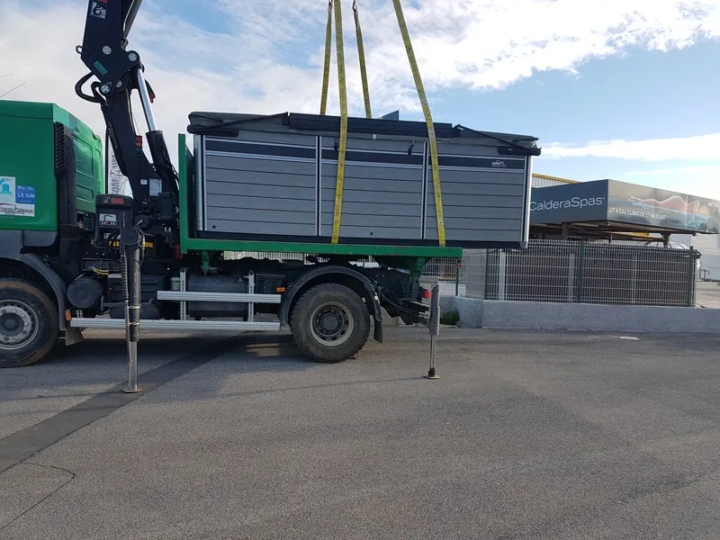Spa de nage Endless Pools posé sur le plateau du camion-grue, encore sanglé