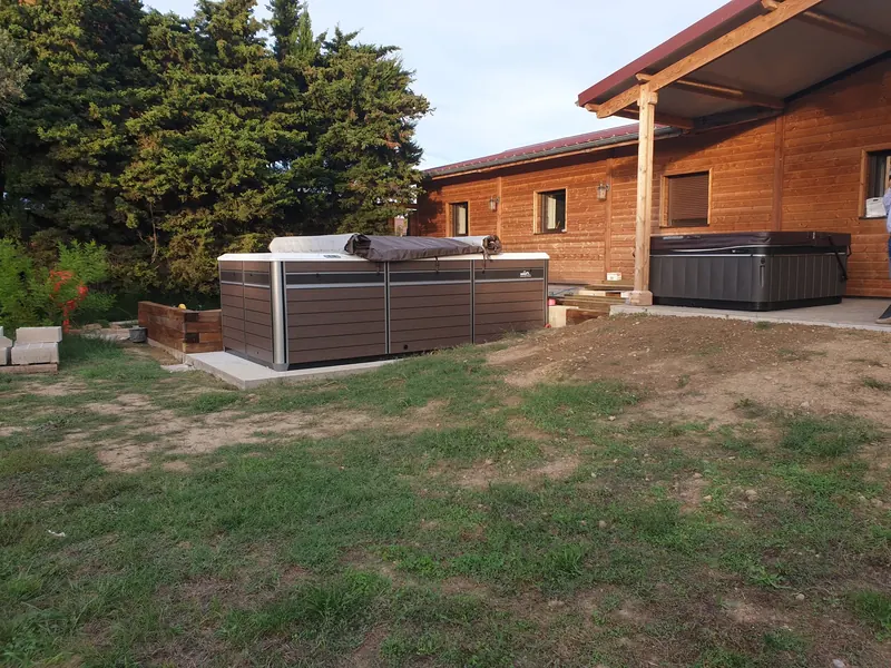 Spa de nage Endless Pools dans le jardin et spa Caldera sous la terrasse couverte d'une maison en bois à Narbonne