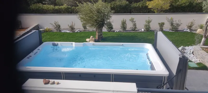 Spa de nage blanc et équipements de détente à côté